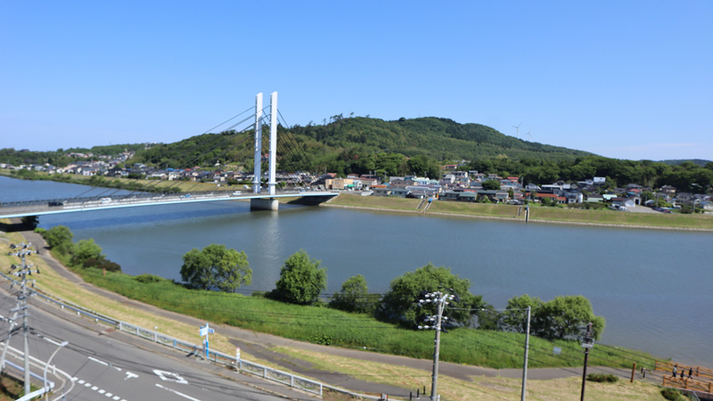 本荘グランドホテル前面に広がる子吉川の流れと緑豊かな由利本荘市せせらぎパークの美しい風景